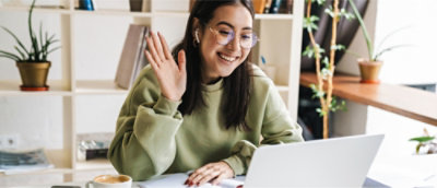 A person waving at a computer