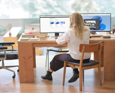 Personne assise à un bureau regardant un ordinateur