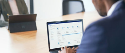 A person pointing at a computer screen.