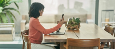 Persona seduta a un tavolo che usa un dispositivo mobile
