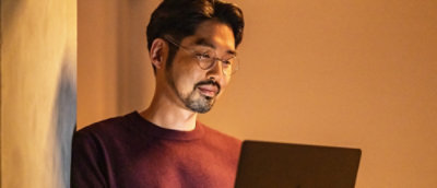 Orang yang mengenakan kacamata sedang melihat laptop.