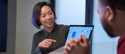 A women showing laptop screen to a man.