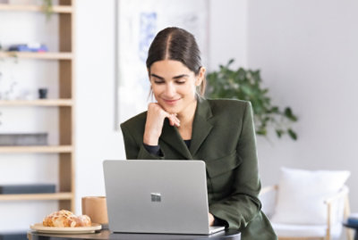 Une personne travaillant sur un ordinateur portable à une table avec un café.