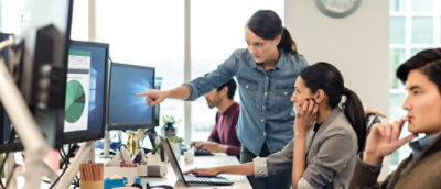 A woman pointing at a computer screen.