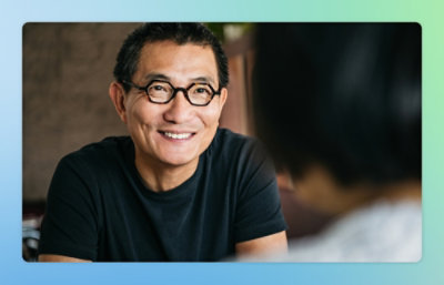 a man wearing glasses and smiling