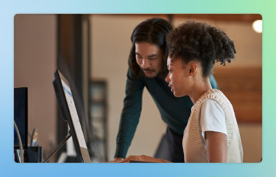 A man and woman working together at a desk in an office.
