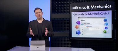 A person standing in front of a screen where microsoft products are displaying