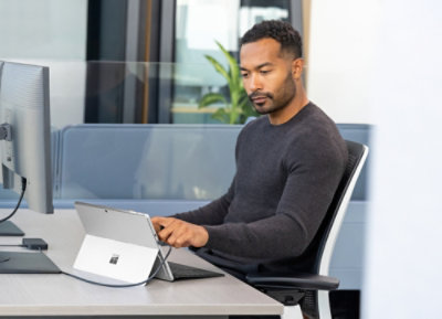 A person sitting at a desk using a tablet.