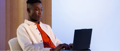 A person in a white jacket using a laptop.