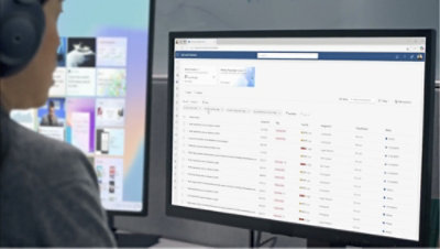 Kulaklık takmış bir kişi, bir web sitesini gösteren bilgisayar ekranına bakıyor.