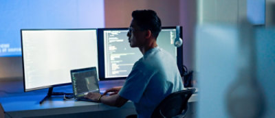 Un homme assis à un bureau avec un ordinateur portable.