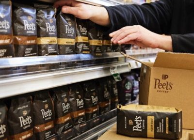 Some one arranging peets coffee packets in a store