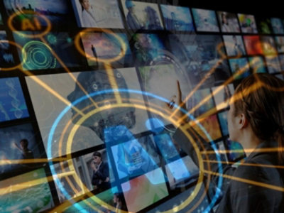 Eine Person schaut auf einen Fernseher, der verschiedene visuelle Inhalte zeigt.