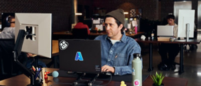 A man is working at a desk in a modern open office