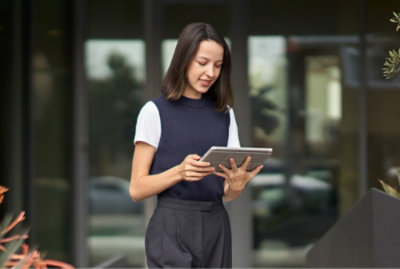 A women holding a tablet and checking something in to it.