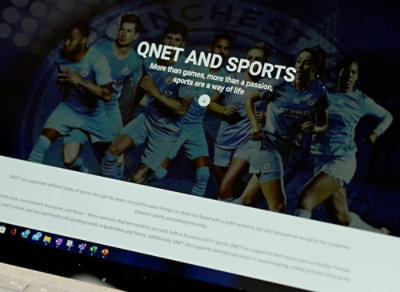 Ekran komputera wyświetlający stronę internetową sportową z obrazem piłkarza.