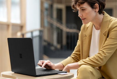 A woman sitting at a table using a laptop.