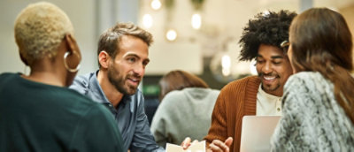 A group of people using a computer and discussing.