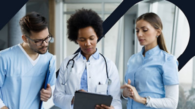 Een groep medische professionals die naar een klembord kijken.