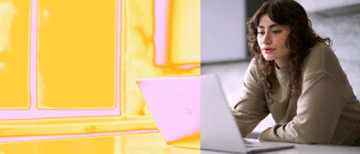 Een vrouw met een bruin shirt die op een laptop werkt