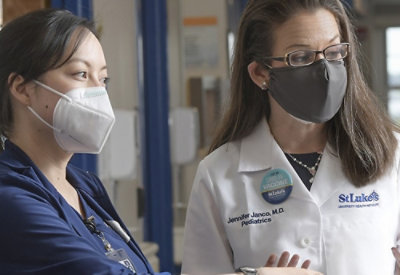 Jennide Janco, M.D., StLuke's Pediatrics yazılı yüz maskesi takan bir kadın.