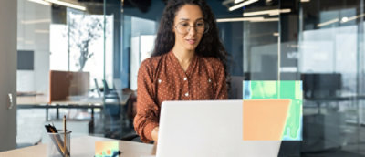A women wearing glasses working on a laptop