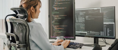 Uma pessoa sentada à mesa trabalhando em um computador.