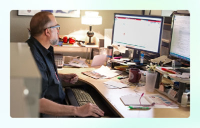 Un homme assis à un bureau utilisant un ordinateur.