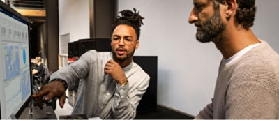 Deux hommes regardent l’écran et discutent