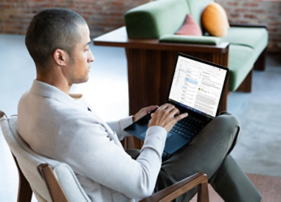En person, der sidder i en stol og bruger en bærbar computer.