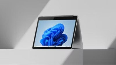 Microsoft-Gerät mit der blauen Blüte auf dem Bildschirm, der auf einem weißen Tisch steht