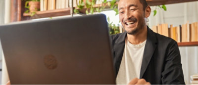 Eine lachende Person, die auf einen Computer schaut