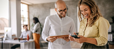 A man and woman looking at a tablet.