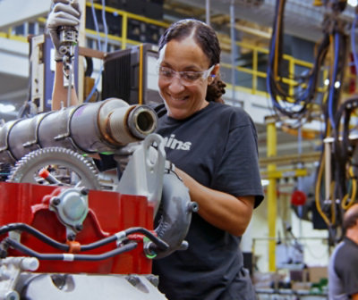 A woman smiling while holding a machine.