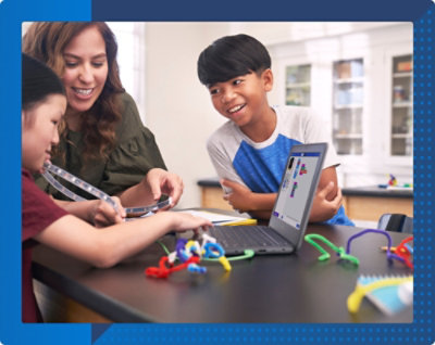 Two students engaged in a classroom activity with educational materials on the table.