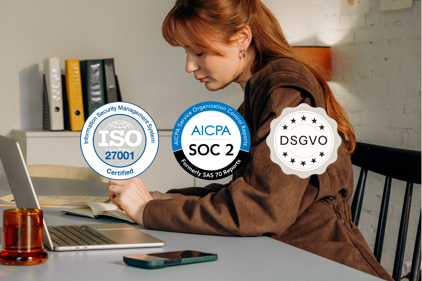 Woman working at a laptop with ISO 27001, SOC 2, and GDPR compliance badges overlaid