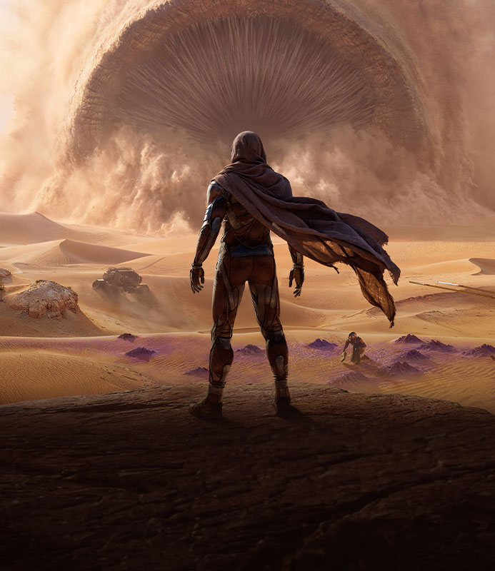 Dune: Awakening, a lone cloaked figure standing in a vast desert canyon and facing a colossal sandworm emerging from a massive cloud of swirling sand.