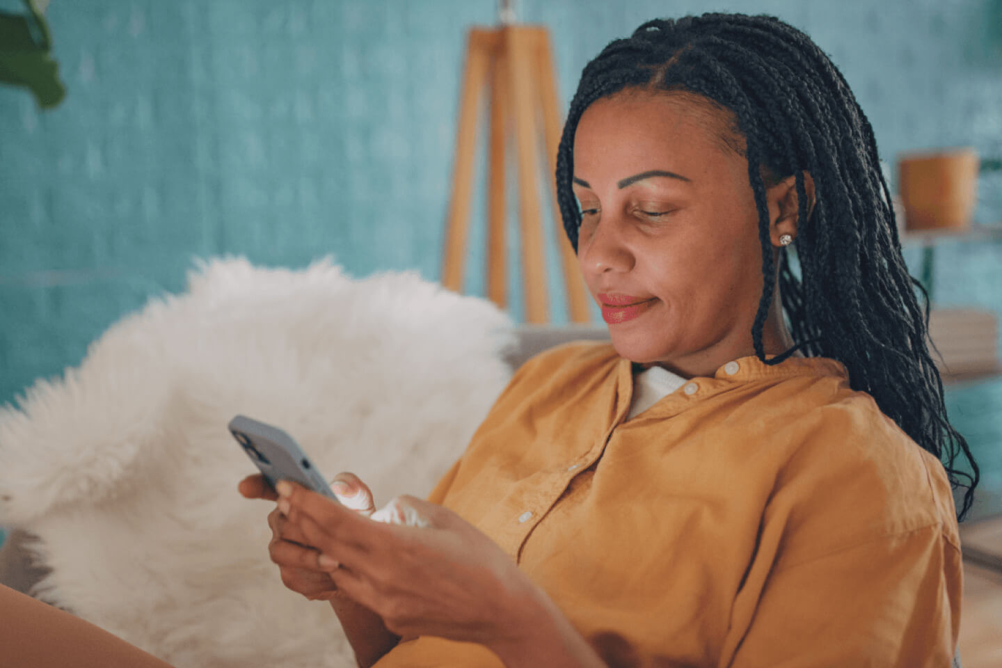 Female customer sat at home holding phone with both hands
