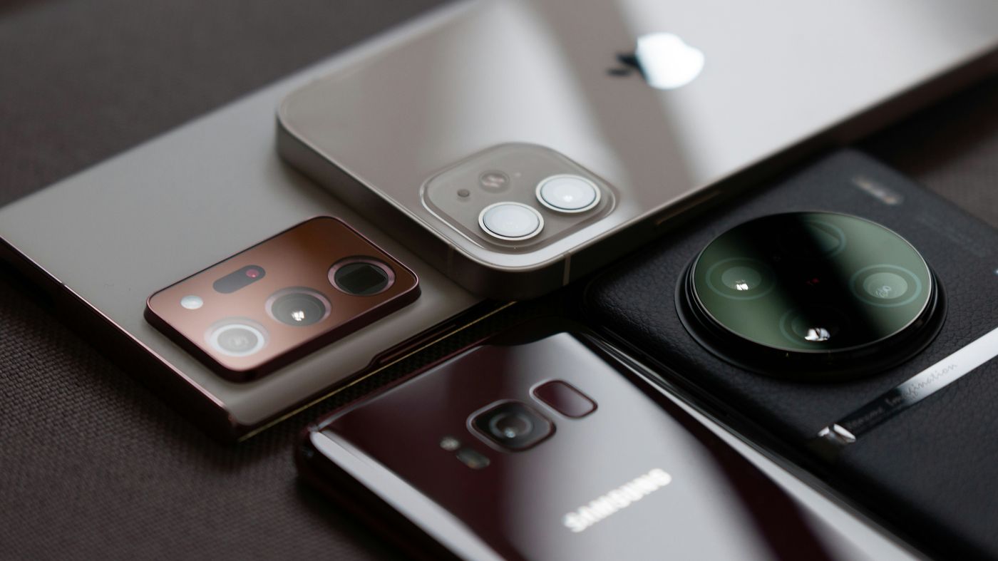 Four grey smartphones on a flat surface Four grey smartphones on a flat surface