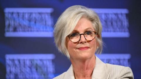 Helen Haines wears glasses and a beige striped suit during an address at the National Press Club in Canberra, Australia.