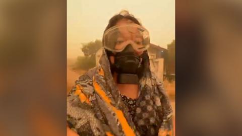 Woman wears an eye and face gas mask