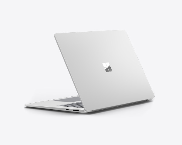 Częściowo otwarty Surface Laptop w kolorze platynowym na jasnym tle.