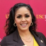 Headshot portrait of Aiddee Tellez smiling in front of a red USC backdrop