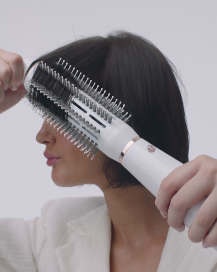 girl using hot air styler on her short hair 