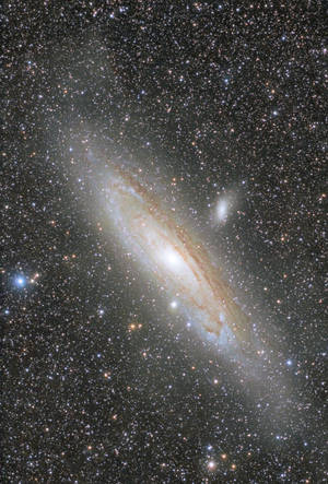 Uma galáxia espiral com núcleo brilhante e braços empoeirados cercados por estrelas — Universo Papéis de Parede