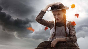 En ung pige med fletninger smiler, mens efterårsblade flyder omkring hende på en stormfuld himmel. — E Wallpapers