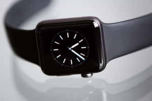 Et sort smartur med hvide visere på en reflekterende overflade. — Apple Watch Wallpapers