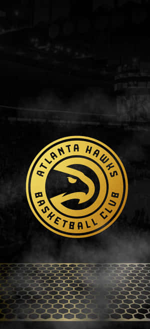 Atlanta Hawks basketball team logo glowing gold in a smoky arena. — OnePlus 11 Wallpaper