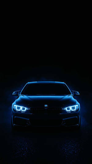 Una BMW nera illuminata da fari blu luminosi nell'oscurità. — Auto Sfondi