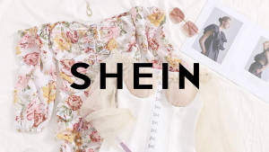 Blusa floral y ropa blanca transparente estilizada en una cama con gafas de sol y revistas de moda. — She Fondos de pantalla